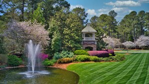Un jardin aménagé avec une fontaine, une pelouse parfaitement entretenue et un kiosque portant l’inscription « The Landing Reynolds ».