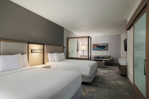 A hotel room with two beds, a sofa, a desk, and a large mirror. - Springhill Suites By Marriott Abilene (Abilene)