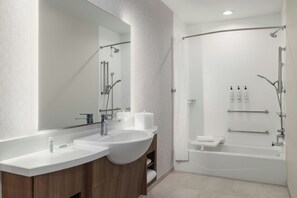 A modern bathroom with a double sink vanity, a large mirror, a walk-in shower with a glass door, and a bathtub. - Springhill Suites By Marriott Abilene (Abilene)