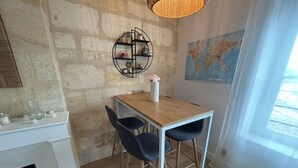 En hyggelig spiseplads med et træbord og to stole, et verdenskort på væggen og en hængende lampe.