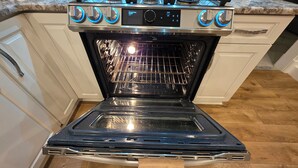 A kitchen with a built-in oven, a stovetop, and a microwave. - Elegant Family Haven (Monaca)