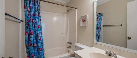 A bathroom with a bathtub, toilet, and sink.