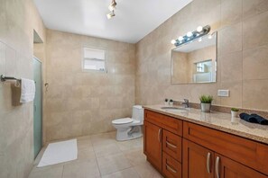 A modern bathroom with a toilet, sink, and vanity.