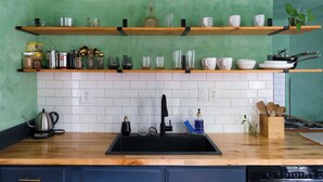 A kitchen with wooden shelves, a black sink, and various kitchen utensils. - Group-Friendly 4BR / 3.5BA / 2 Kitchens + Private Homes Side-by-Side  Sleeps 10 (Dayton)