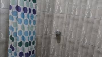 Een douche, handdoeken, zeep, toiletpapier