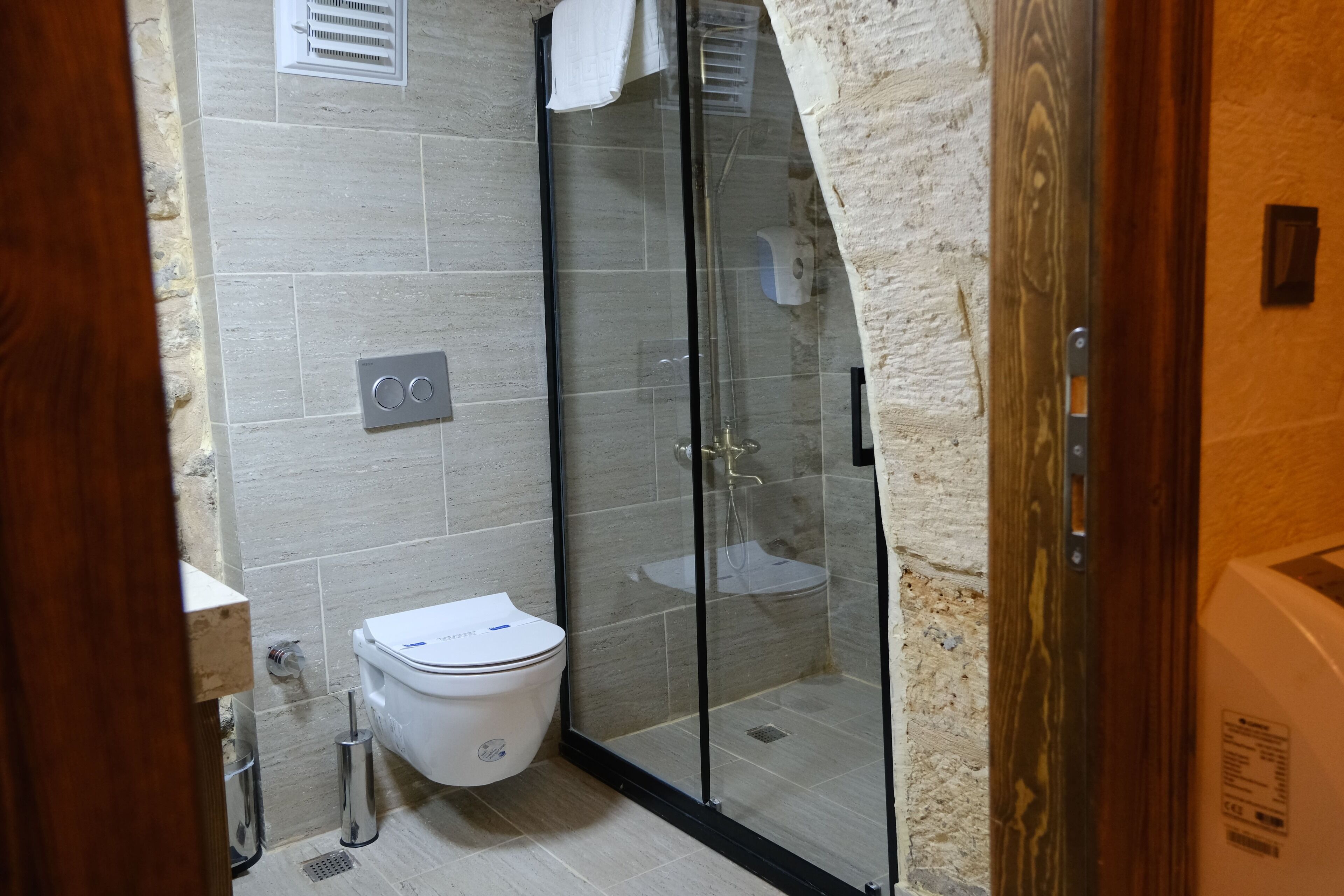 Un baño moderno con ducha de vidrio, inodoro y lavamanos.