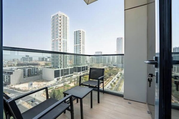 Un balcon offrant une vue sur de hauts immeubles et sur le paysage urbain.