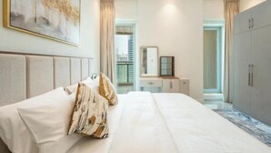 Un dormitorio moderno con una cama grande, una mesita de noche, un armario y una lámpara en el techo.