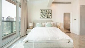 Un dormitorio moderno con una cama grande, vistas a la ciudad y una decoración minimalista.