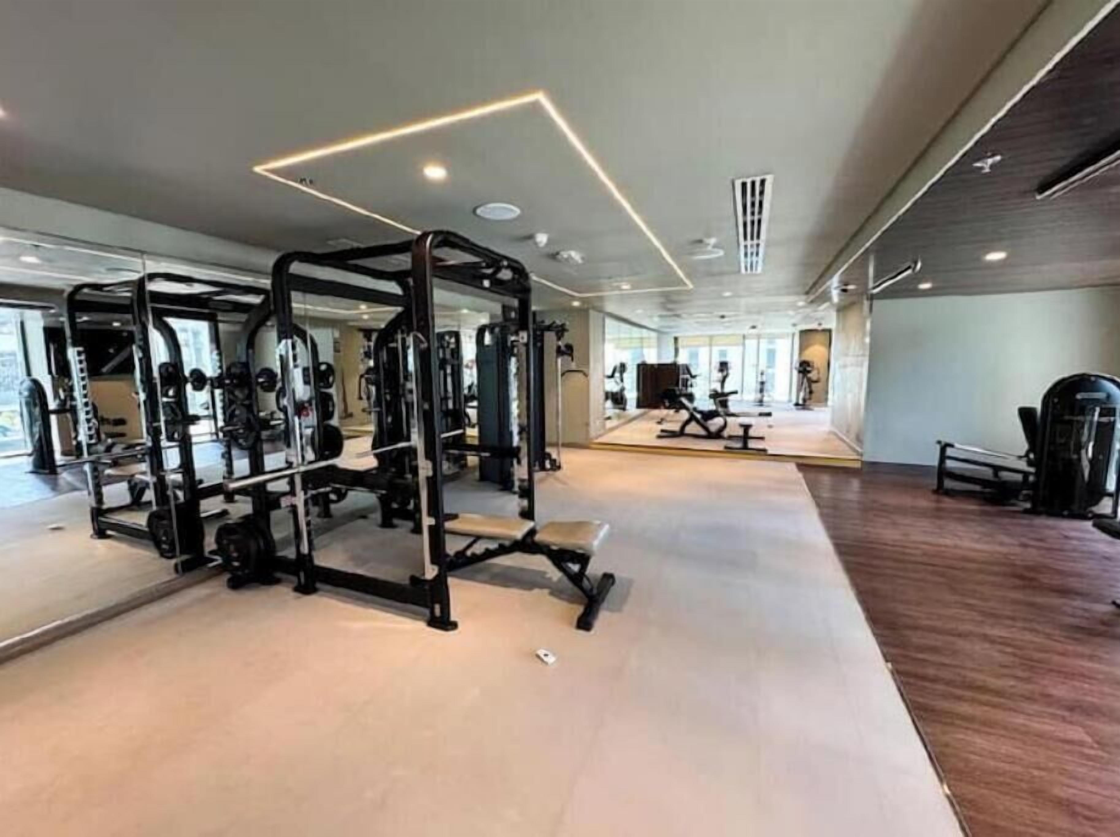 Een ruime fitnessruimte met diverse trainingsapparaten, waaronder krachtapparaten en cardioapparaten.