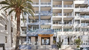 A multi-story hotel with a prominent 'PEPPERS' sign, balconies, and a palm tree in the foreground. - The Manly Wave Beachfront Ocean Views (Manly)