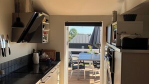Una cocina moderna con una puerta corredera que da a un área de comedor al aire libre.