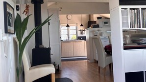 Un espacio habitable moderno con cocina, comedor y una gran planta en maceta.