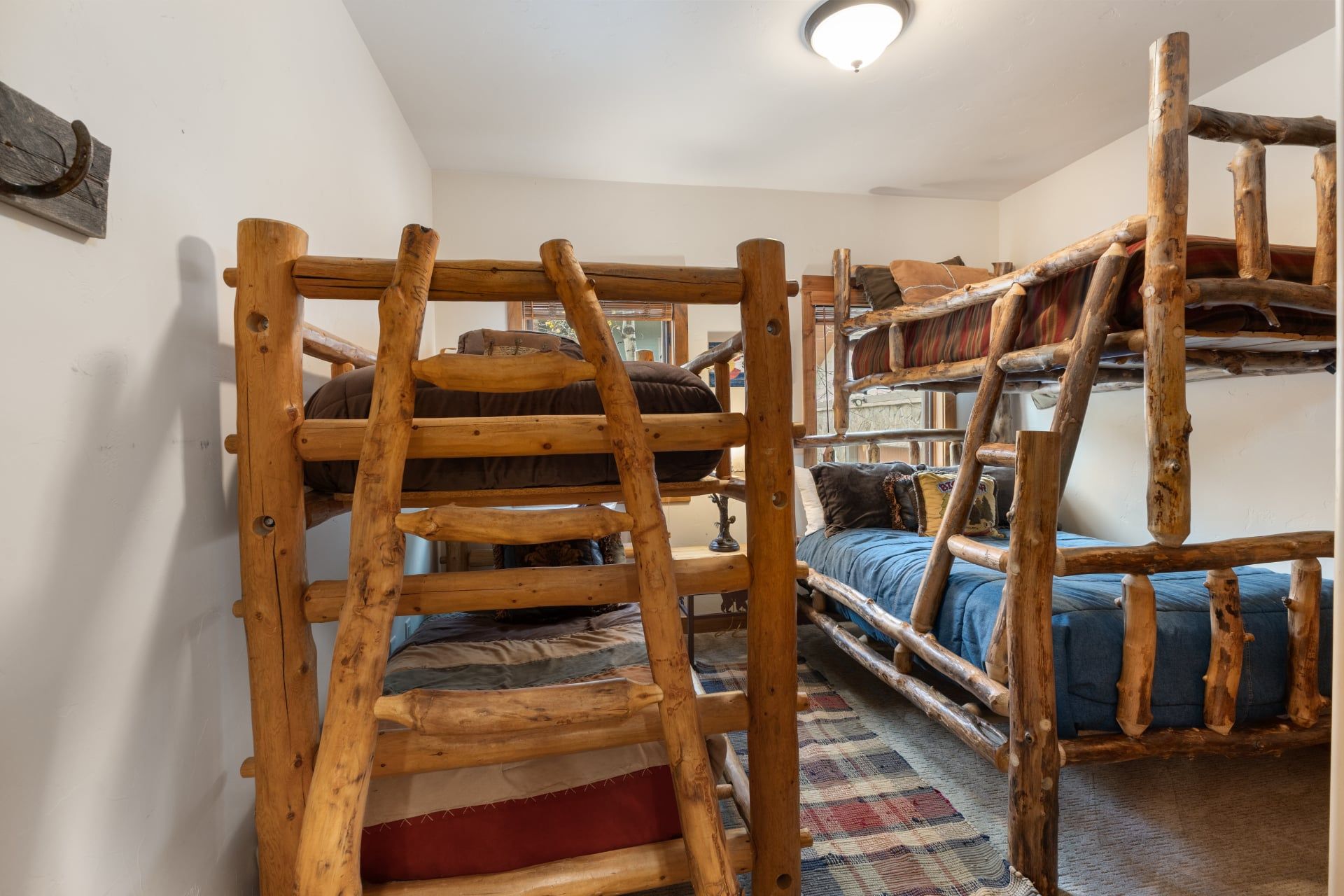 A bunk bed room with wooden railings and a ladder.