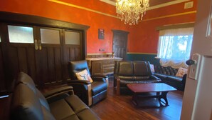 A room with dark wood furniture, a chandelier, and a window with curtains. - Pink Lakes Quairading (Quairading)