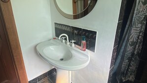 A bathroom with a white sink, a mirror, and a shower curtain. - Pink Lakes Quairading (Quairading)