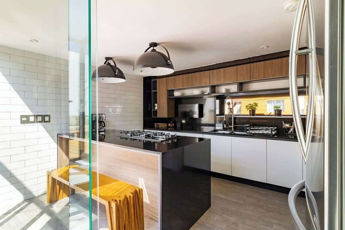 A modern kitchen with a central island, stainless steel appliances, and pendant lighting.