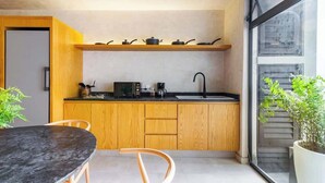 Een moderne keuken met houten kastjes, een zwart aanrecht en een raam met uitzicht.
