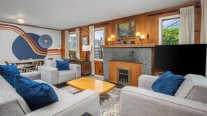 Een moderne woonkamer met een open haard, banken en een televisie.