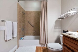 Une salle de bain équipée d’une baignoire, d’une douche, de toilettes et d’un meuble-lavabo.