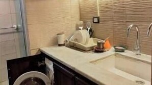 Una cucina con mobili in legno scuro, un lavello e una lavatrice.