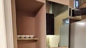 Una cucina compatta con frigorifero, piano cottura e dispenser di acqua.