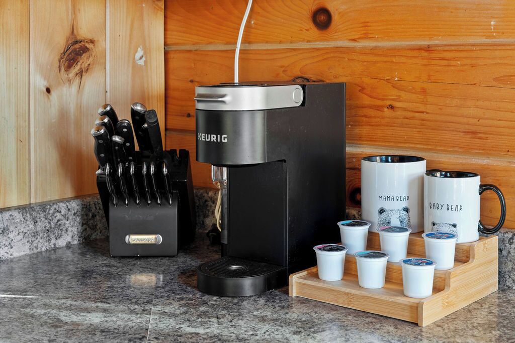 A coffee maker, a knife block, and a mug set on a kitchen counter.