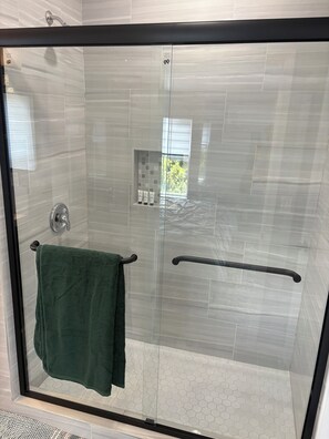 Een douche, handdoeken, zeep, toiletpapier