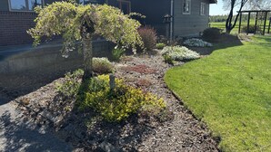 Une maison d’habitation dotée d’un jardin bien entretenu, d’un chemin menant à l’entrée et d’une pelouse.