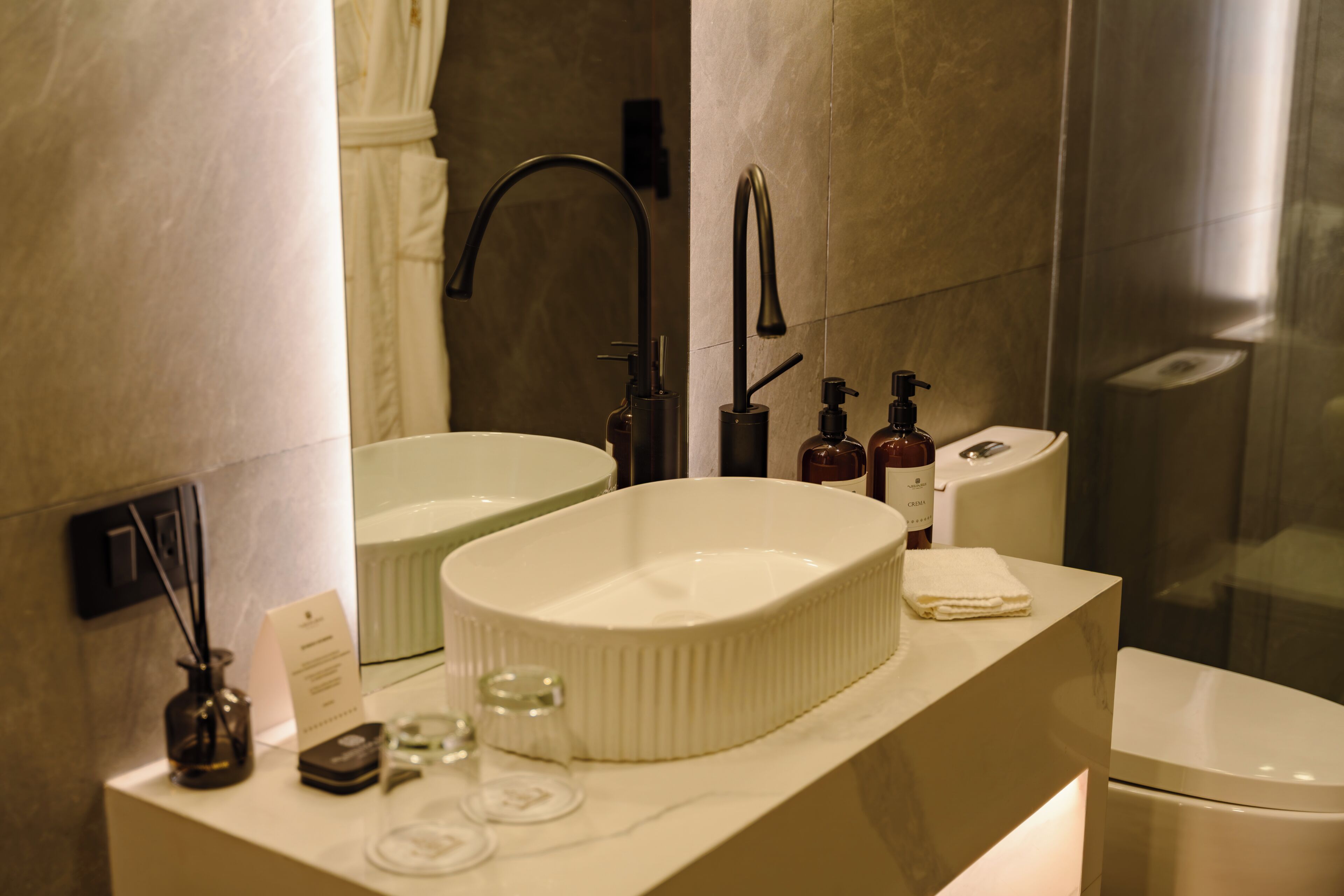A modern bathroom with a dual sink vanity, a toilet, and a glass shower enclosure.