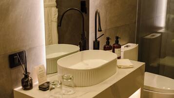 A modern bathroom with a dual sink vanity, a toilet, and a glass shower enclosure.