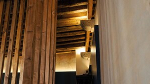A wooden staircase with a sloped ceiling and a wall-mounted light fixture. - Por los Siglos Hotel (Huamantla)