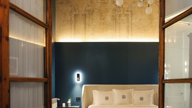 A bedroom with a bed, bedside table, and a nightstand. - Por los Siglos Hotel (Huamantla)