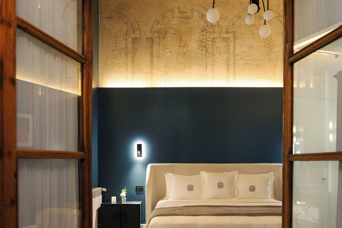Un dormitorio con cama, mesita de noche y tocador.