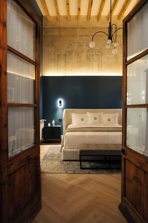 A bedroom with a bed, bedside table, and a nightstand. - Por los Siglos Hotel (Huamantla)