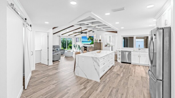 Una cocina amplia con una isla grande, electrodomésticos modernos y vistas al exterior.