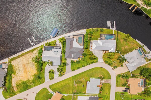 Vista aérea de una zona residencial con casas, piscina y muelle.