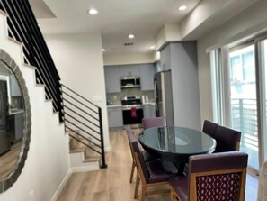 A modern kitchen with grey cabinets, a stainless steel refrigerator, and a microwave. - Stylish 2BR Suite in Vibrant LA Area -> Complimentary WiFi, AC & Parking (Los Angeles)