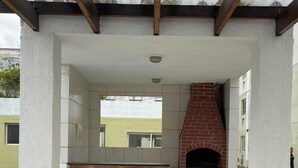 Eine Terrasse im Freien mit einem Backofen aus Ziegelsteinen und Fliesenböden.