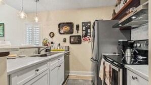 A kitchen with white cabinets, a stainless steel refrigerator, a coffee maker, and a microwave. - 3 Miles from beach. 2-bedroom, 2 bath condo in Little River with 3 beds. (Little River)