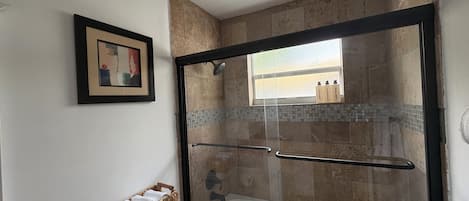 Regadera, secadora de cabello, toallas, papel de baño
