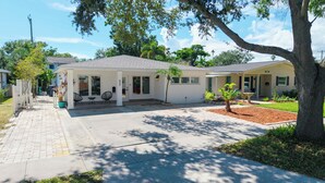 A single-story house with a covered porch, a small garden, and a driveway.