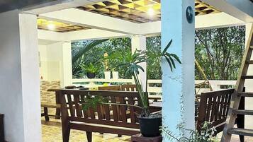 An outdoor seating area with wooden benches and potted plants.