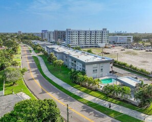 Un moderno complejo hotelero con varias edificaciones, piscina y estacionamiento.