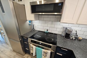 A modern kitchen with stainless steel appliances, a microwave, and a kettle. -  Sun, Sand & Sunsets–all just minutes from your door. (St. Petersburg)