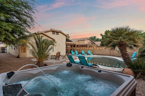 Ein Whirlpool mit Pool, Liegestühlen und einem Haus mit Terrasse.