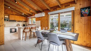 A wooden interior with a kitchen, dining area, and large windows. - Spacious | Pet Friendly| Near Boat Ramp and Water (Clifton Springs)