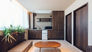 Una cocina moderna con armarios de madera oscura, un refrigerador empotrado y una pequeña encimera.