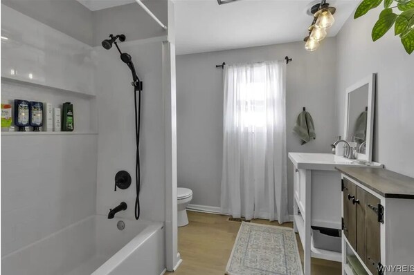 Un baño moderno con ducha, inodoro y lavamanos.