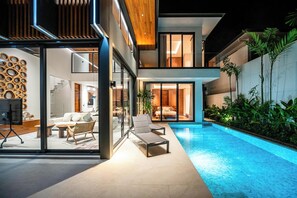 A modern house with a glass-enclosed living area, a pool, and a balcony with plants. - Elite Chalong Villas (Chalong)